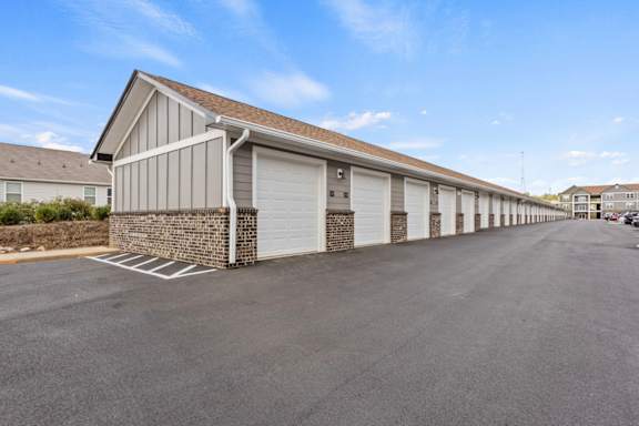 A long building with garage doors is in the foreground.