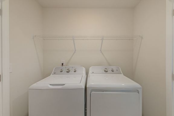 In unit washer and dryer with overhead shelving at The Courts at Maverick Yards Apartments, South Carolina, 29662