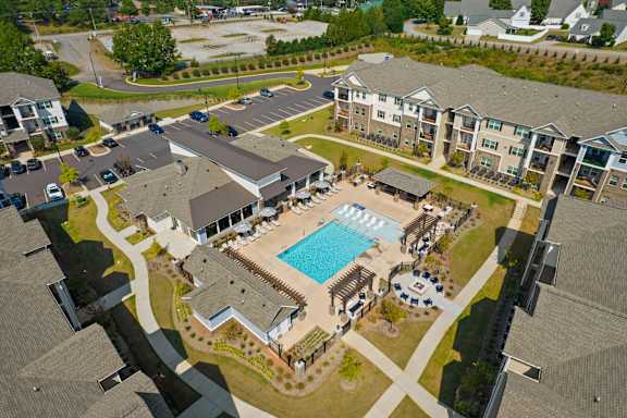 An aerial view of a housing complex with a swimming pool.