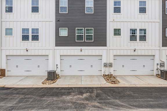 Three attached garage doors with decorative hardware accents at The Courts at Maverick Yards Apartments, Mauldin, South Carolina