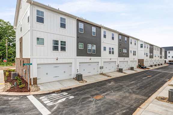 Row of attached garages with modern townhome facades at The Courts at Maverick Yards Apartments, Mauldin