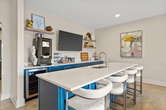 A modern kitchen with blue cabinets and white countertops.