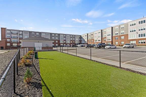 A parking lot is in front of a building with a green lawn.