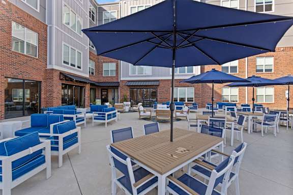 A patio with blue chairs and tables.