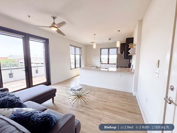 A living room with a couch and a fan.