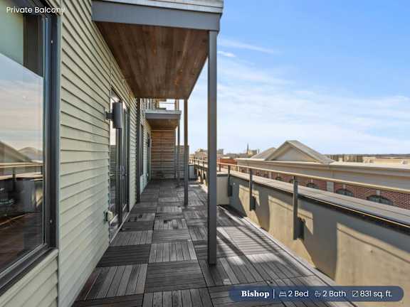 A balcony with a wooden floor and a metal railing.