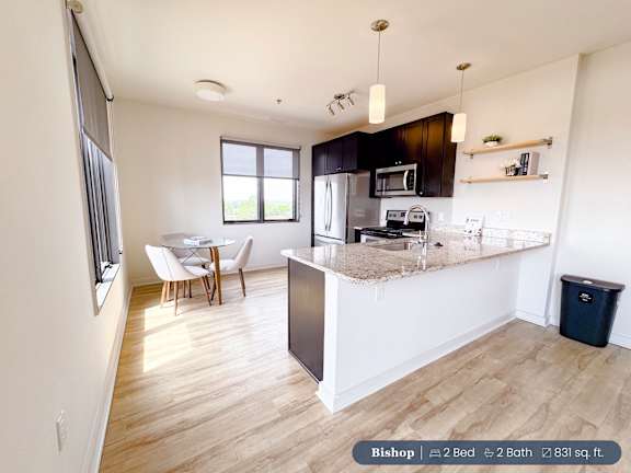 A kitchen with a refrigerator, microwave, and oven.