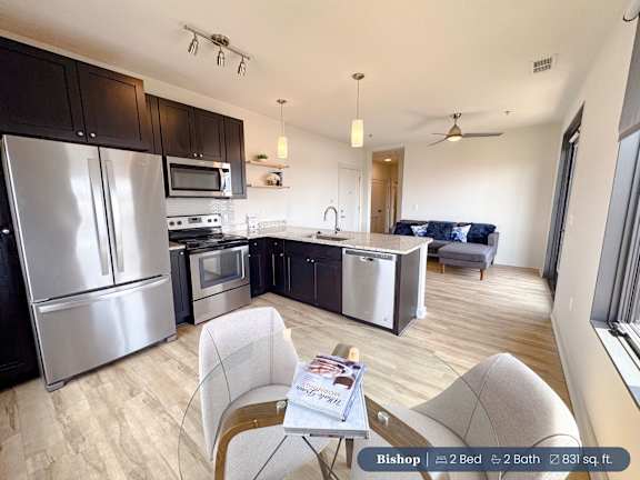 A kitchen with a refrigerator, microwave, oven, and sink.