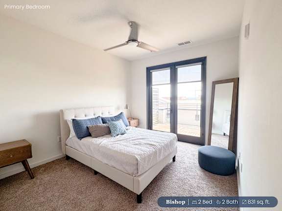A bedroom with a bed, a bench, and a window.