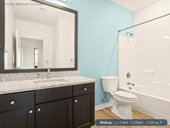 A bathroom with a white toilet and a mirror above a counter.