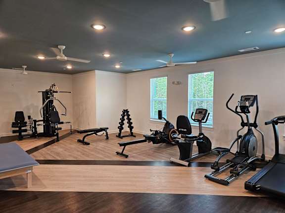Ovata at Reedy Creek's fitness center, featuring a multi-gym station, a leg extension machine, dumbbells, a rowing machine, a stationary bike, an elliptical and a treadmill.