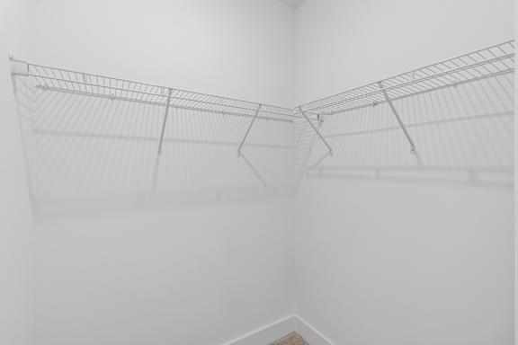A white wire shelf in a white room.