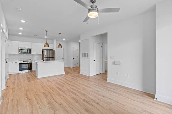A modern kitchen with a wooden floor and white walls.
