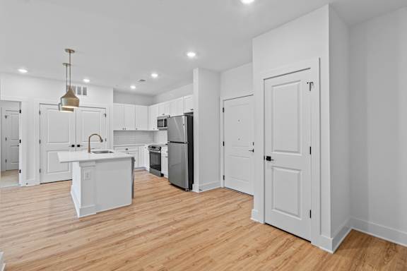 A kitchen with white cabinets and a white island.