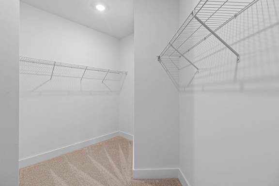 Empty room with a carpeted staircase and a metal rack.