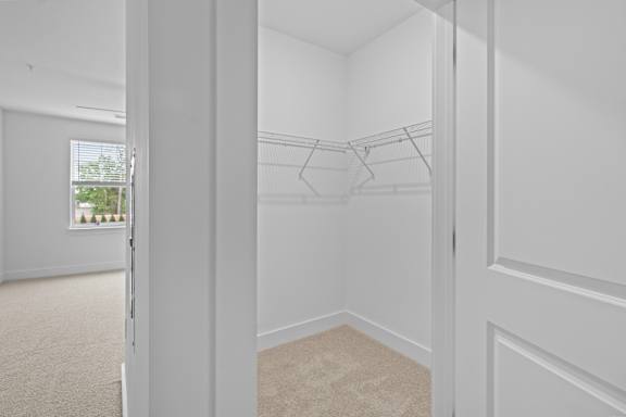 A white room with a carpeted floor and a white door.