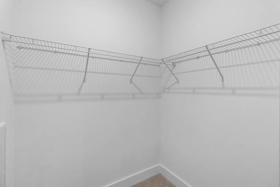 A white wall with a wire shelf attached to it.