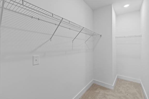 Empty room with a wire shelving unit and a carpeted floor.