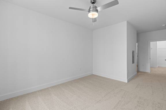 A room with a ceiling fan and carpeted floor.