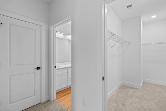 A white room with a door and a closet.