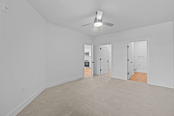 A room with a ceiling fan and carpeted floor.
