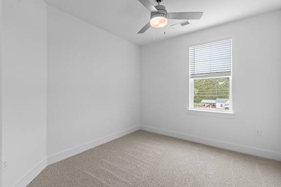 A room with a ceiling fan and a window with blinds.