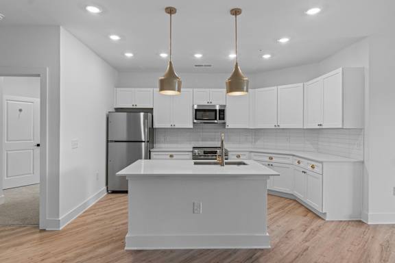 A modern kitchen with white cabinets and a central island.