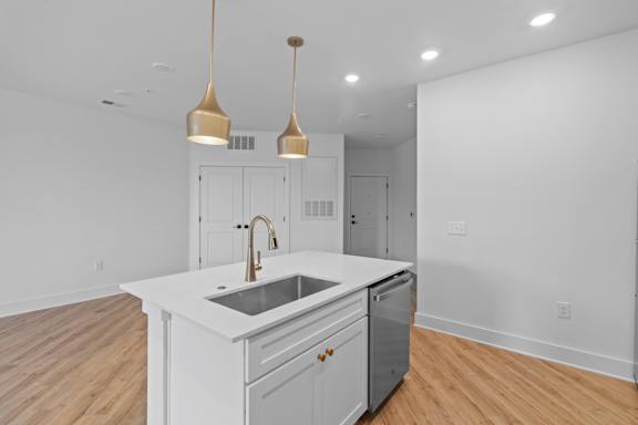 A kitchen with a white countertop and a sink.