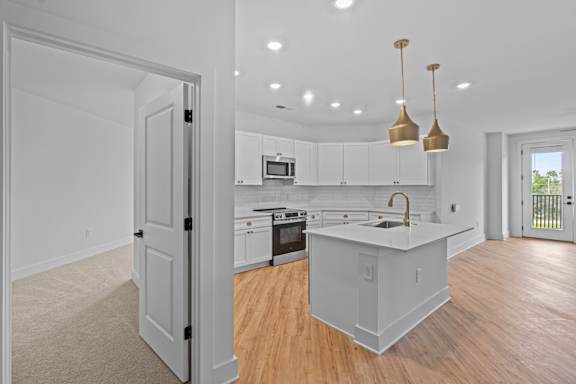 A kitchen with white cabinets and a sink.