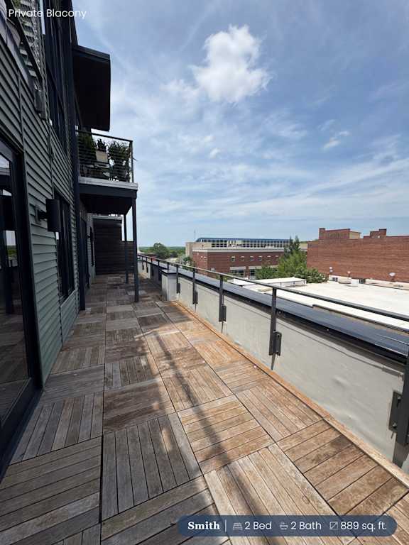 A balcony with a wooden floor and a metal railing.