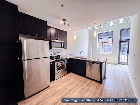A kitchen with black cabinets and stainless steel appliances.