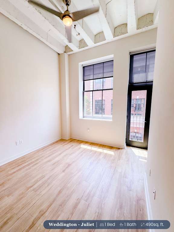 A room with a window and a ceiling fan.