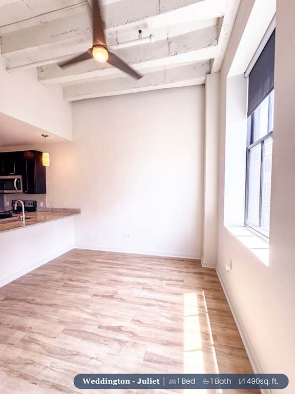 A room with wooden flooring and a ceiling fan.