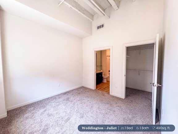 A bedroom with a bed, a bathroom, and a closet.