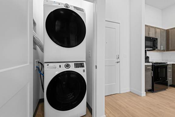 A white front loading washing machine in a laundry room.