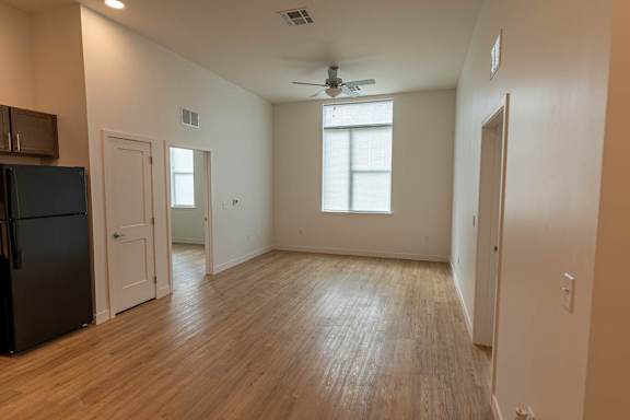 A room with wooden flooring and a ceiling fan at 36N Apartments, Tulsa