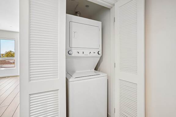 A white washing machine is built into a wall in a room.