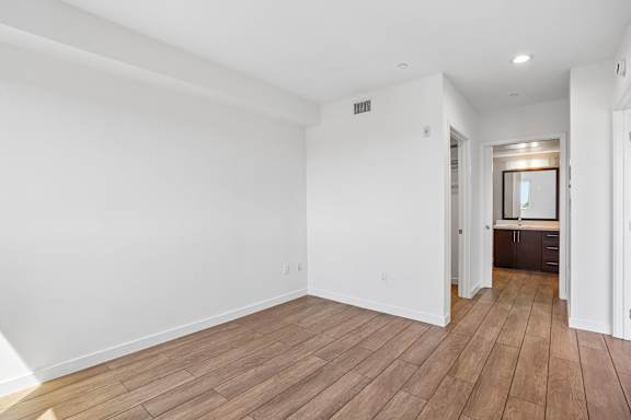 A room with wooden flooring and white walls.