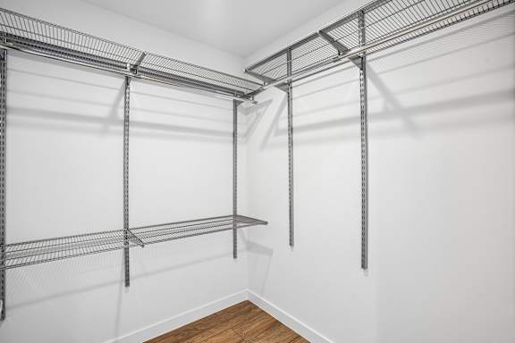 A white wall with a metal shelf on it.