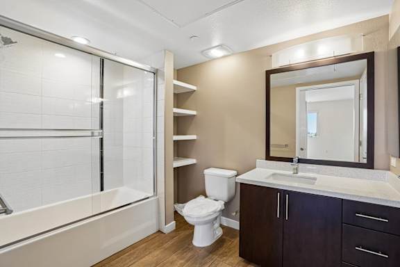 A bathroom with a toilet, sink, and a walk-in shower.