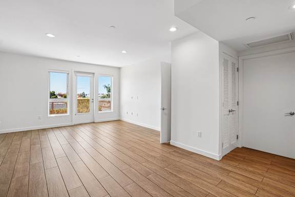 A room with wooden flooring and white walls.