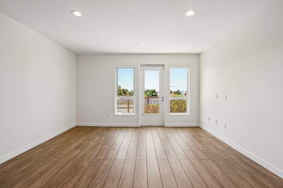 A room with a white wall and a wooden floor.