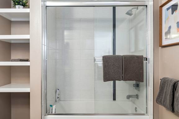 Bathroom with a glass shower door and a towel hanging on the door.
