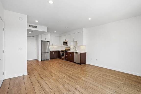 A kitchen with wooden floors and white walls.