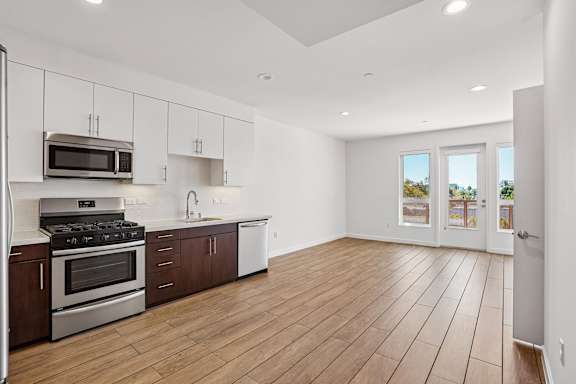 A kitchen with wooden floors and white walls.