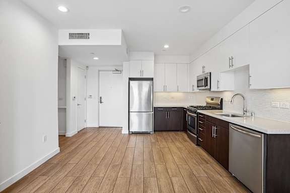 A kitchen with wooden floors and white walls.