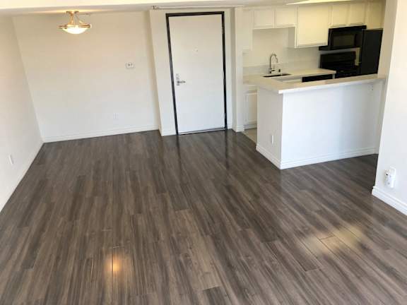 A kitchen area with a black fridge and microwave.
