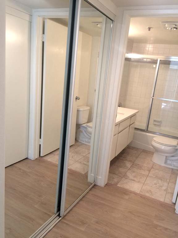 A white toilet is in a bathroom with a walk-in shower.