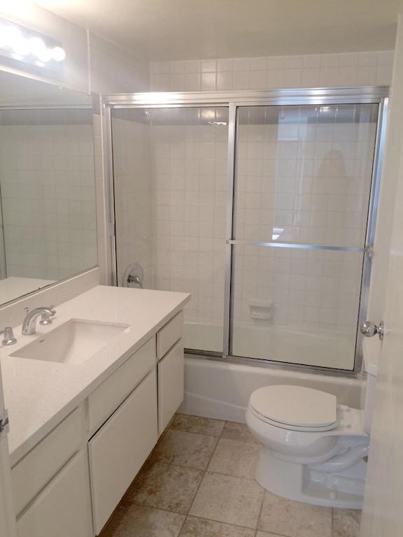 A white toilet sits next to a sink in a bathroom.