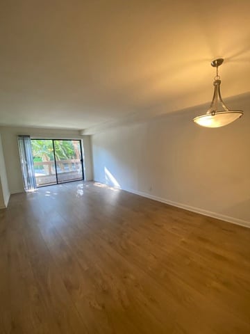 A room with wooden flooring and a ceiling fan.